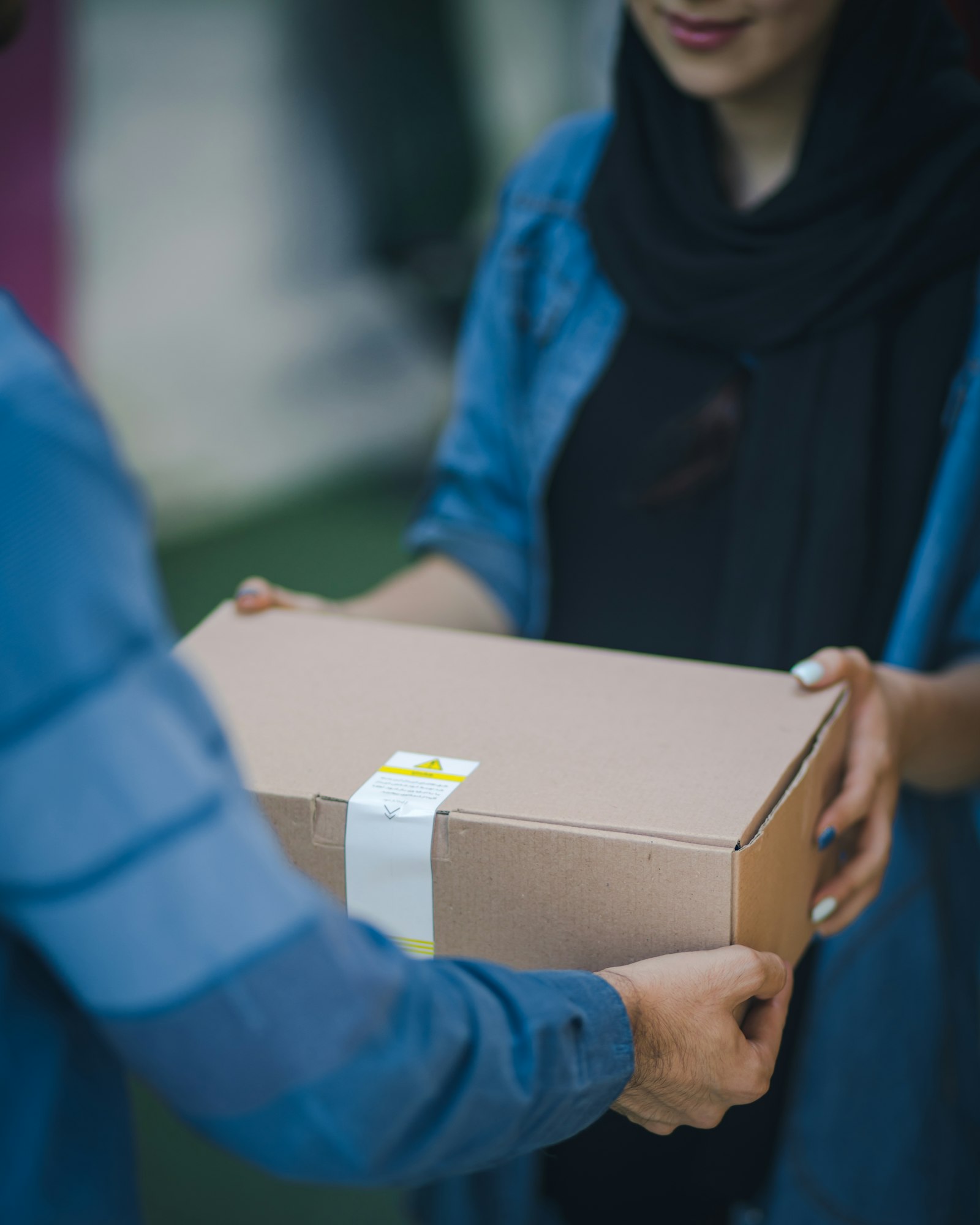 A parcel being handed from one courier to another